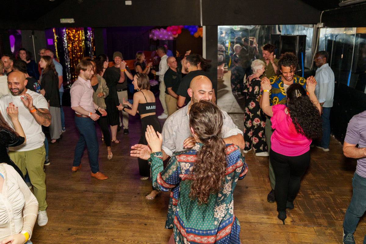 A packed room of people dancing salsa